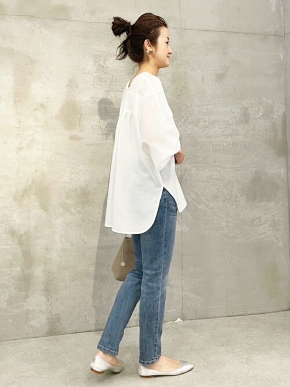 ホワイト系のシャツ/ブラウス、ブルー系のデニムパンツ、グレー系のショルダーバッグを着用したレディースの冬コーディネートの1枚目の写真