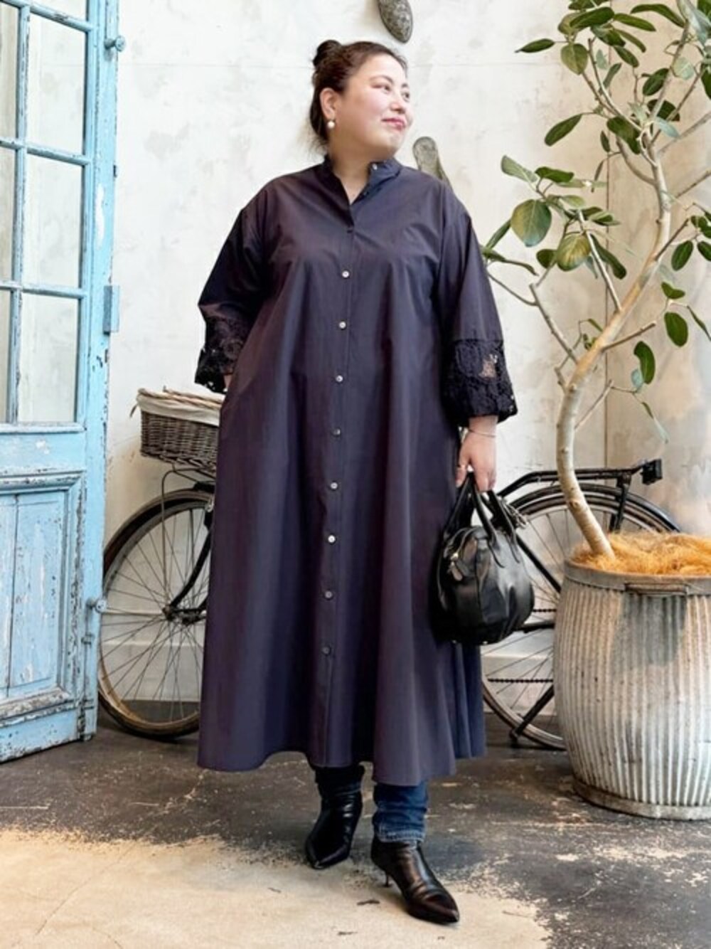 ブルー系のワンピース、ブルー系のデニムパンツ、ブラック系のショルダーバッグを着用したレディースの冬コーディネートの1枚目の写真