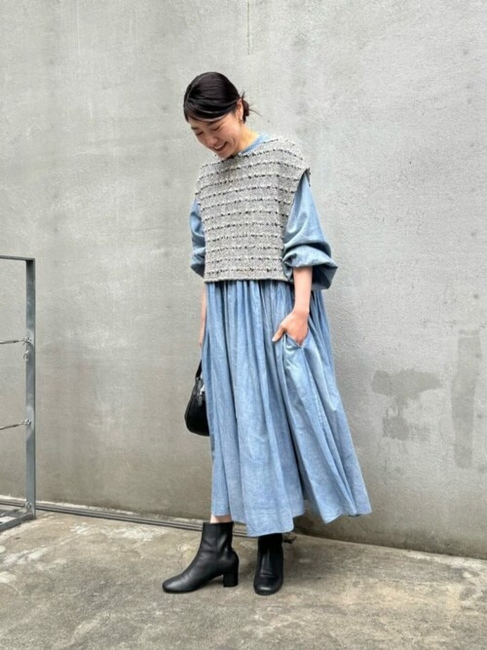 ブラック系のニット/セーター、ブルー系のワンピース、ブラック系のショルダーバッグを着用したレディースの冬コーディネートの1枚目の写真