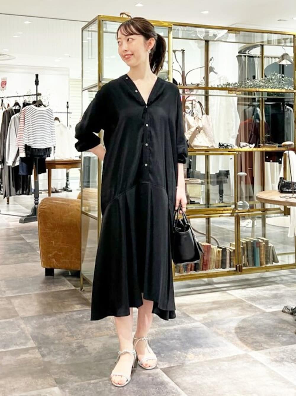 ブラック系のワンピース、ブラック系のトートバッグを着用したレディースの春コーディネートの1枚目の写真