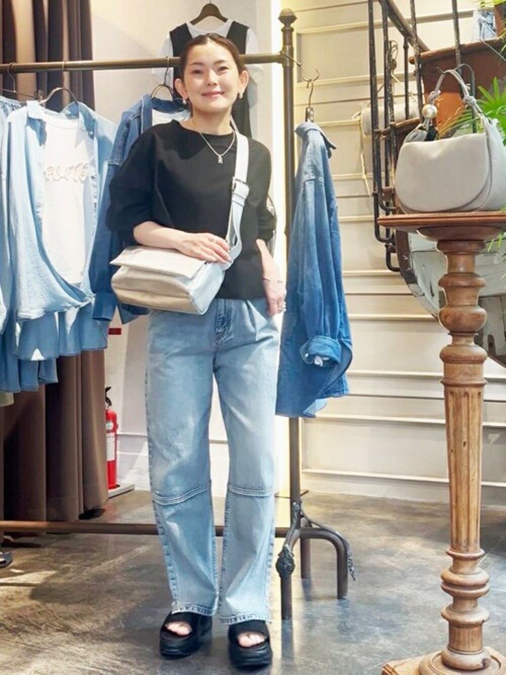ホワイト系のTシャツ/カットソー、ブルー系のデニムパンツ、シルバー系のショルダーバッグを着用したレディースの春コーディネートの1枚目の写真