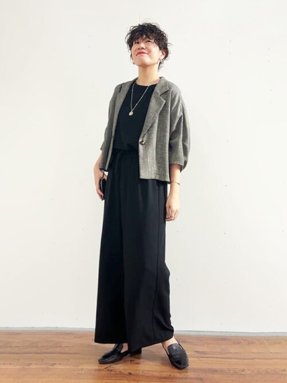 ブラック系のテーラードジャケット、ブラック系のシャツ/ブラウス、ベージュ系のボストンバッグを着用したレディースの春コーディネートの1枚目の写真