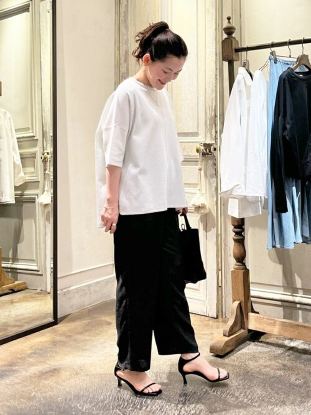 シルバー系のニット/セーター、グレー系のその他パンツ、ブラック系のトートバッグを着用したレディースの春コーディネートの1枚目の写真