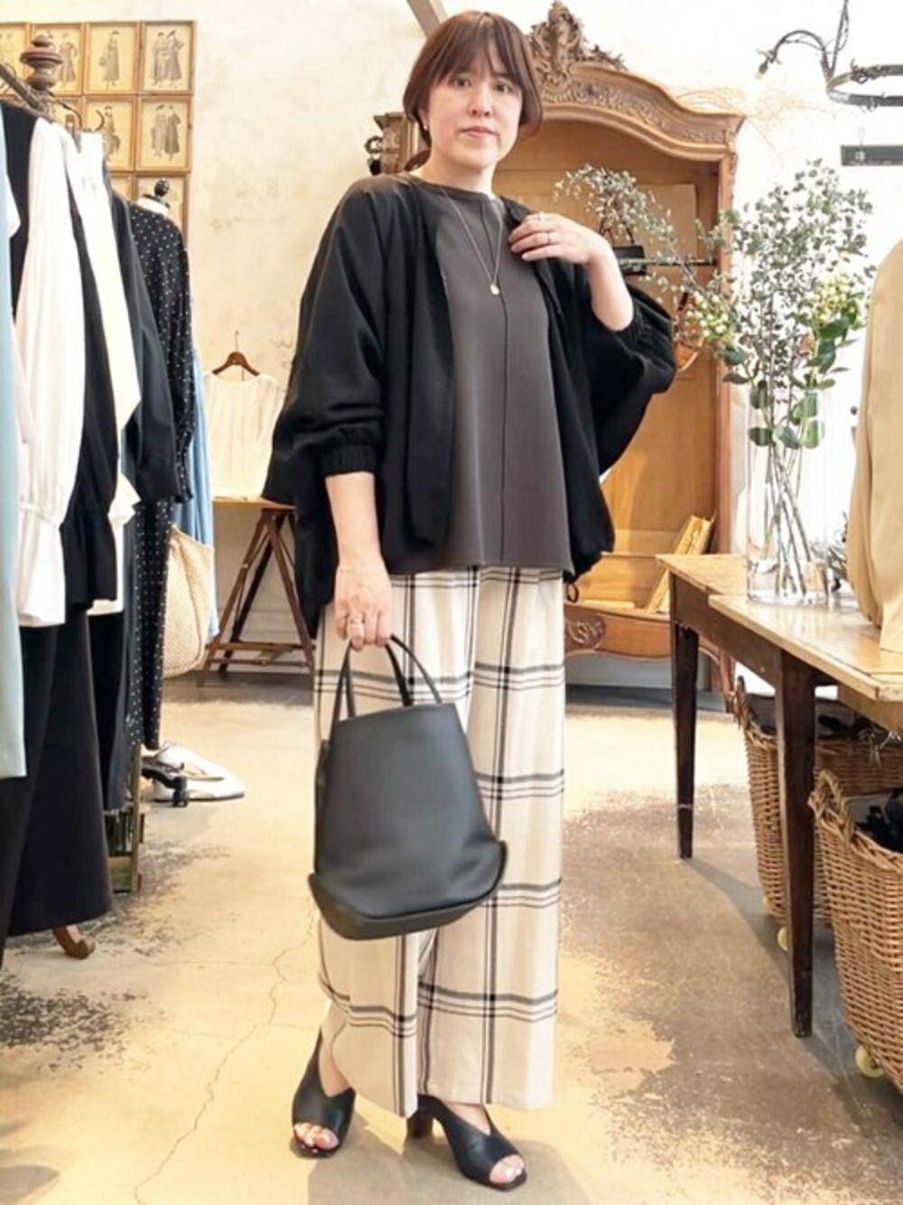 ブラック系のブルゾン、ブラック系のニット/セーター、ホワイト系のその他パンツを着用したレディースの春コーディネートの1枚目の写真