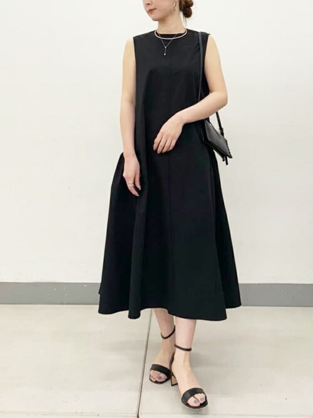 ブラック系のワンピース、シルバー系のピアス(両耳用)を着用したレディースの春コーディネートの1枚目の写真