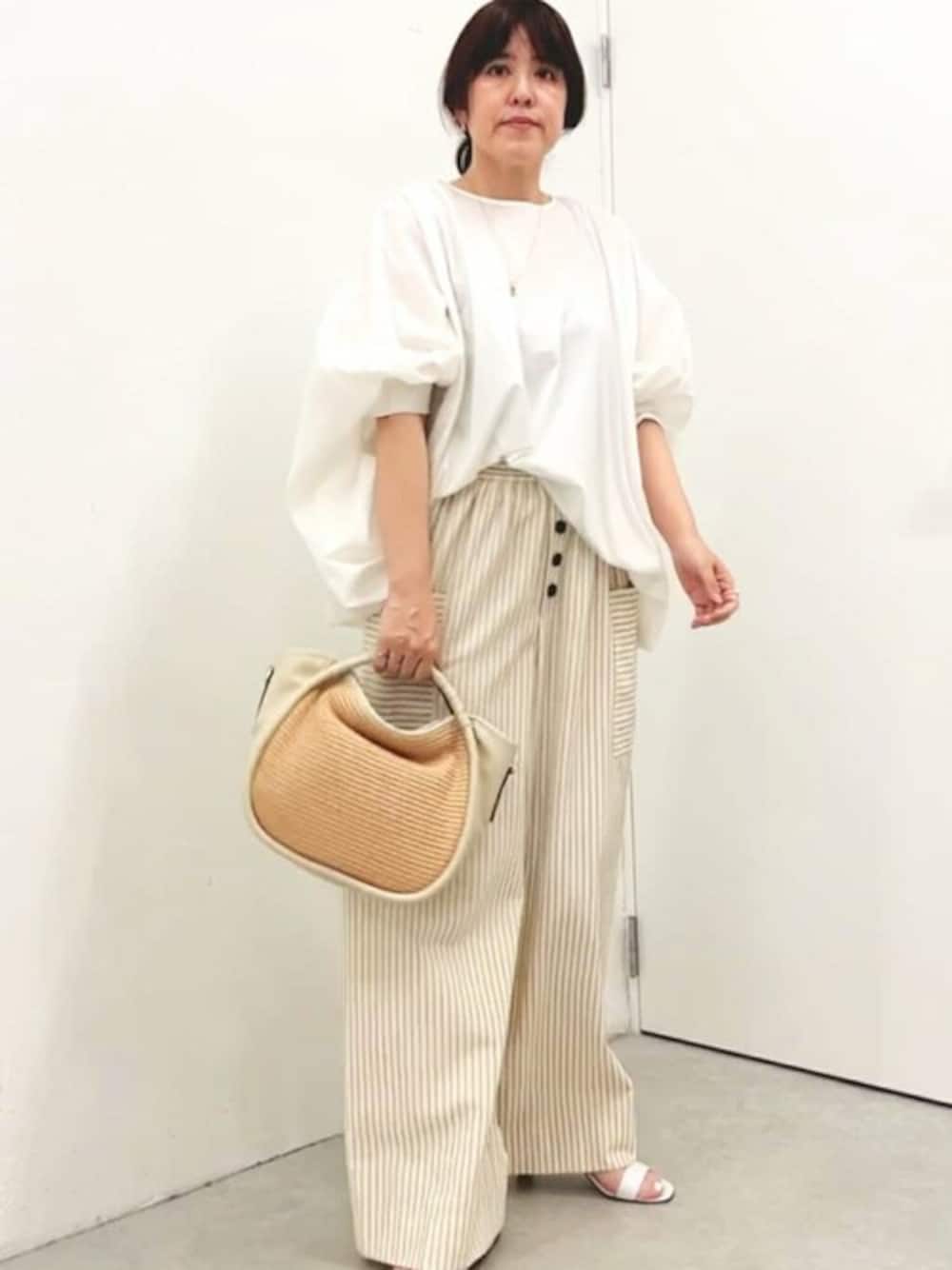 ホワイト系のTシャツ/カットソー、ベージュ系のその他パンツ、ホワイト系のトートバッグを着用したレディースの春コーディネートの1枚目の写真