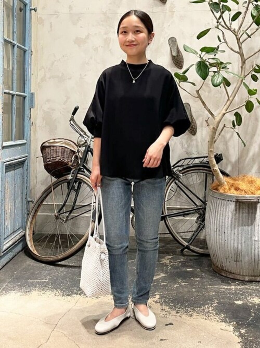 ブラック系のシャツ/ブラウス、ブルー系のデニムパンツ、ホワイト系のトートバッグを着用したレディースの春コーディネートの1枚目の写真