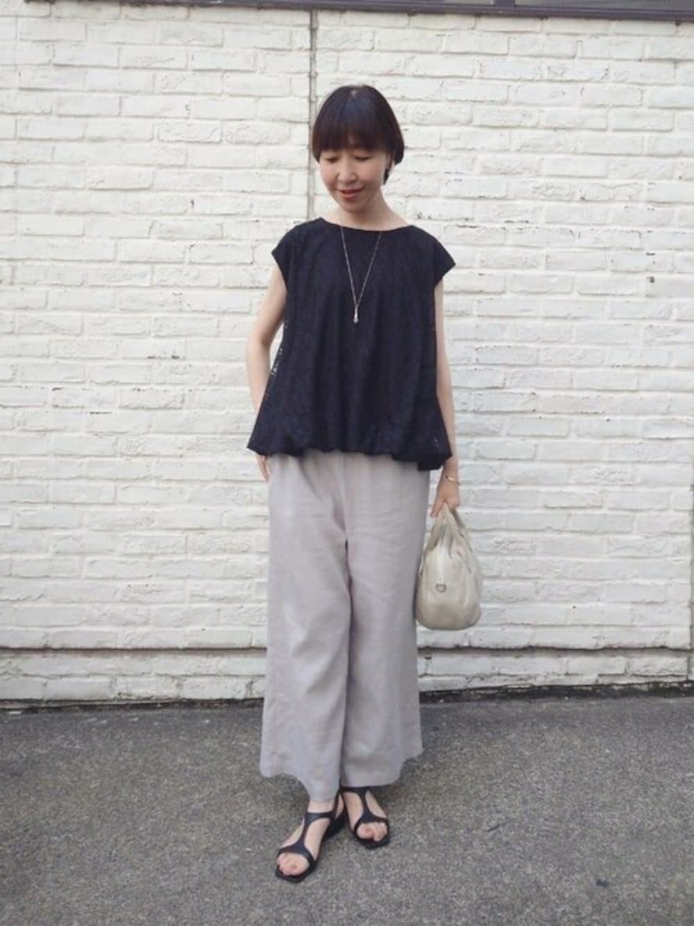 ブラック系のシャツ/ブラウス、グレー系のその他パンツ、グレー系のショルダーバッグを着用したレディースの春コーディネートの1枚目の写真