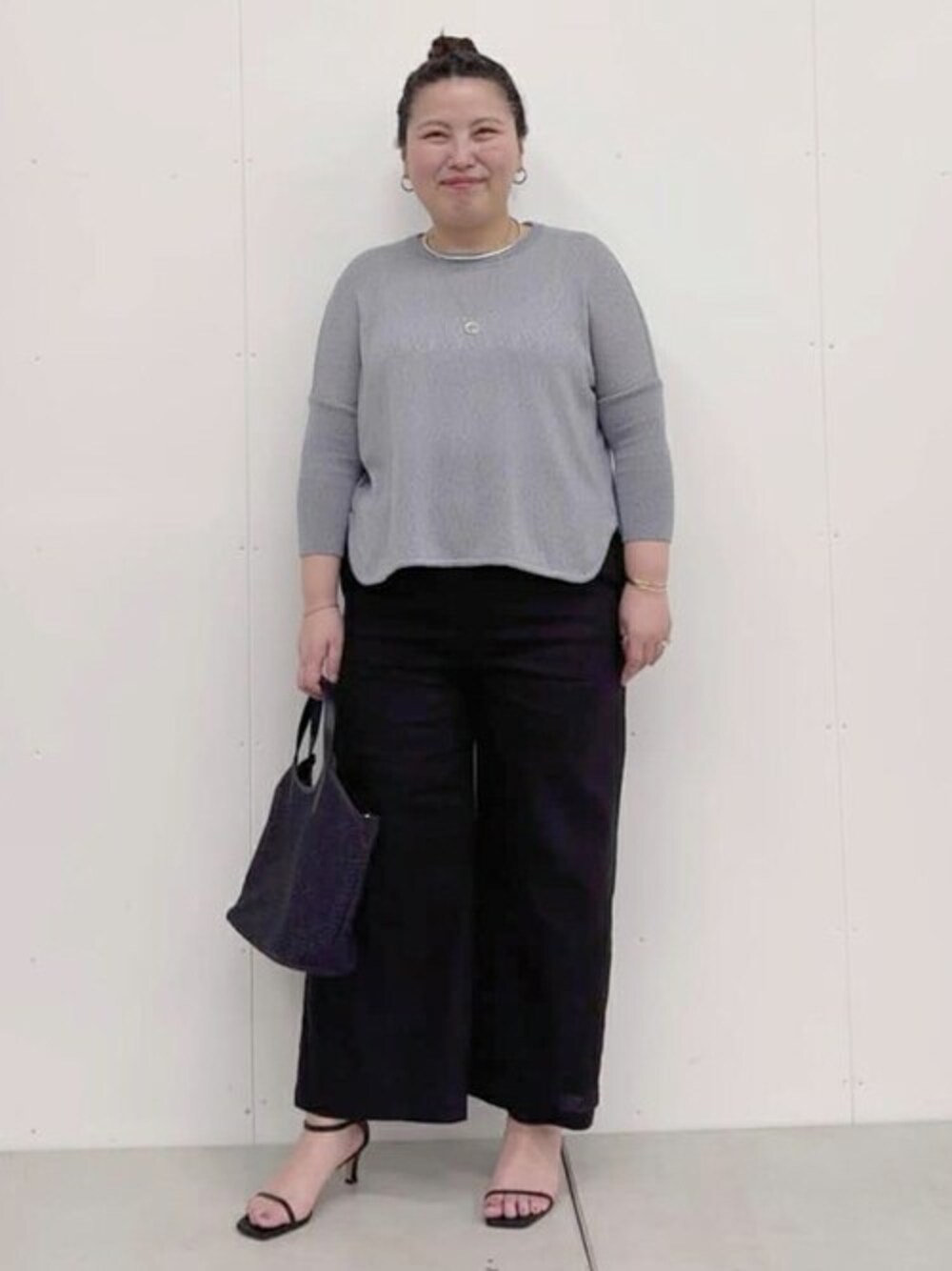 グレー系のニット/セーター、ブラック系のその他パンツ、ブラック系のトートバッグを着用したレディースの春コーディネートの1枚目の写真