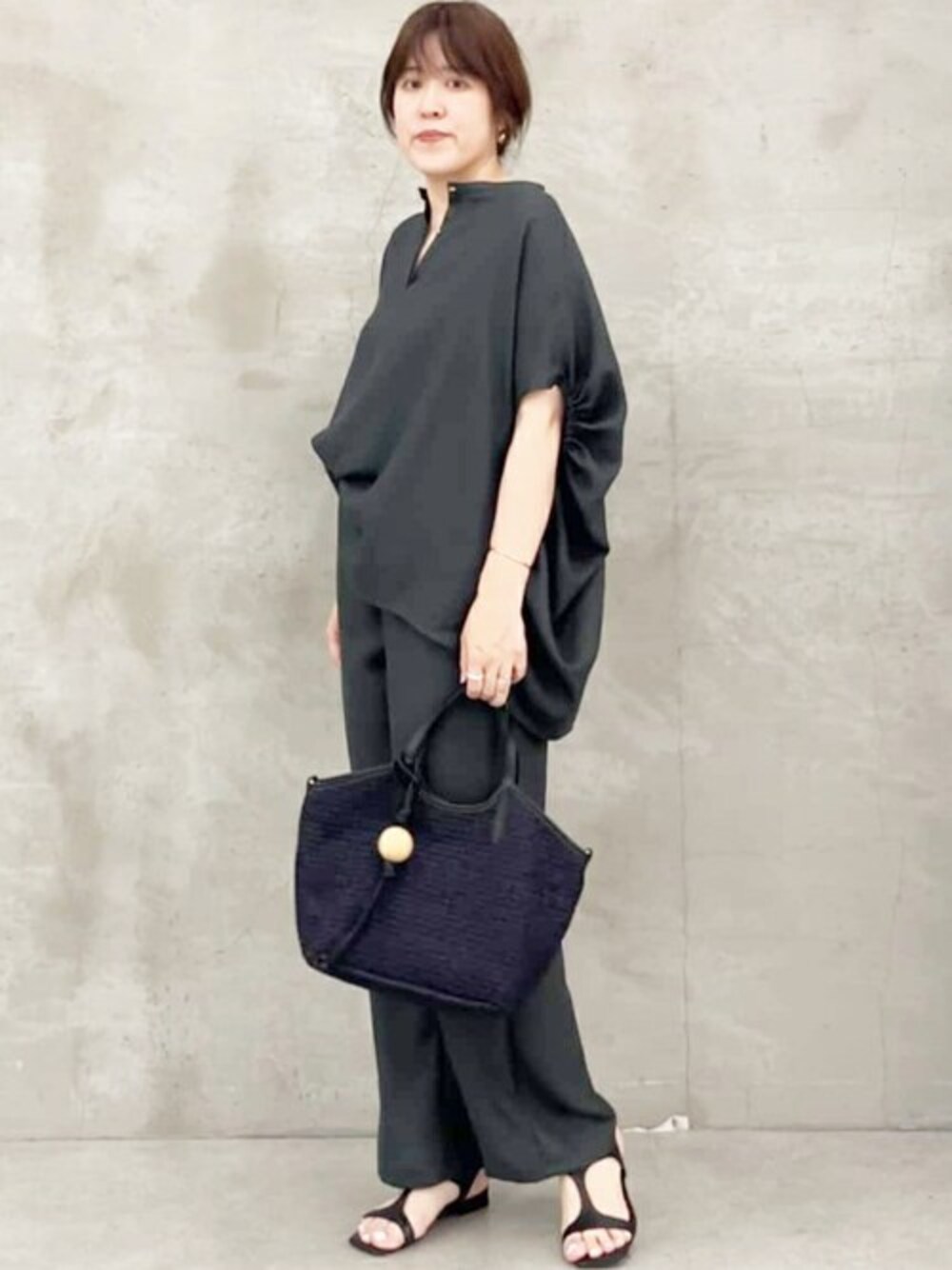 グレー系のシャツ/ブラウス、グレー系のその他パンツ、ブラック系のトートバッグを着用したレディースの春コーディネートの1枚目の写真