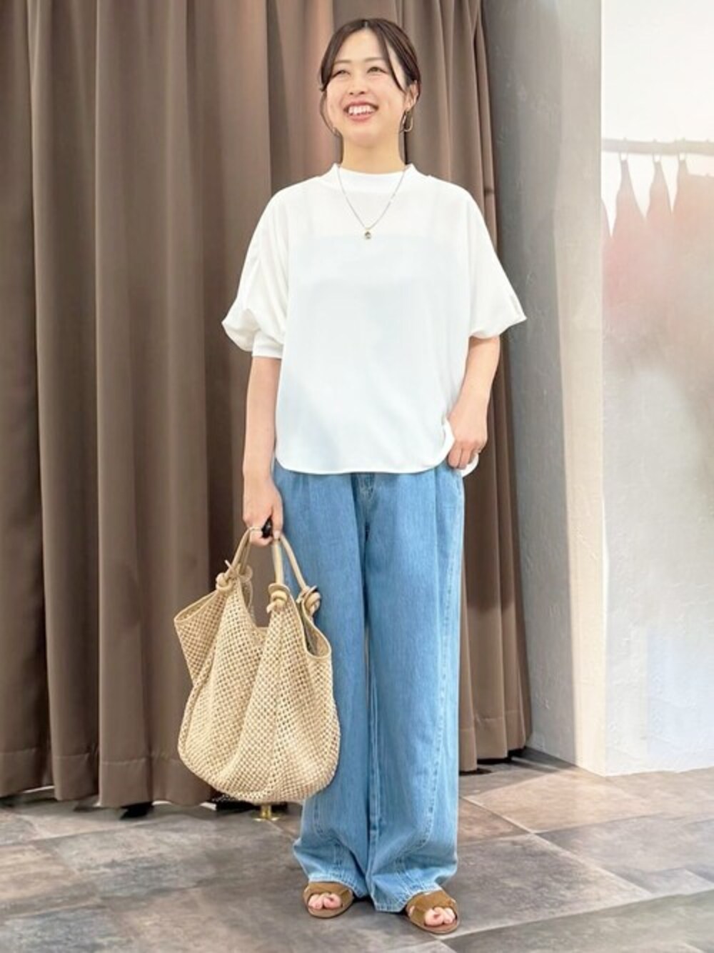 ホワイト系のシャツ/ブラウス、ブルー系のデニムパンツ、ベージュ系のトートバッグを着用したレディースの春コーディネートの1枚目の写真