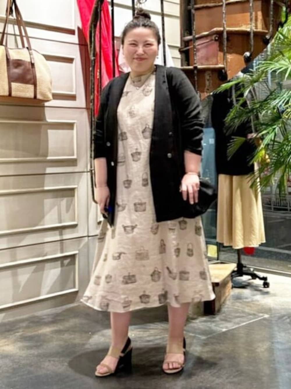 ブラック系のブルゾン、ベージュ系のワンピース、ブラック系のトートバッグを着用したレディースの春コーディネートの1枚目の写真