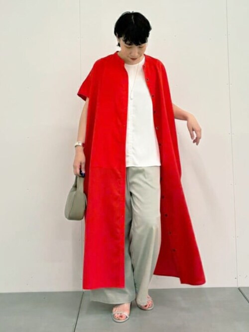 レッド系のワンピース、グレー系のその他パンツ、ブラック系のトートバッグを着用したレディースの春コーディネートの1枚目の写真