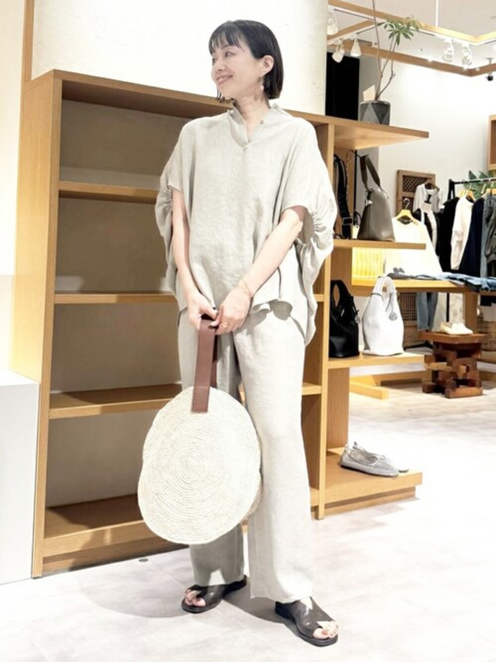 ベージュ系のシャツ/ブラウス、ベージュ系のその他パンツ、ベージュ系のかごバッグを着用したレディースの夏コーディネートの1枚目の写真