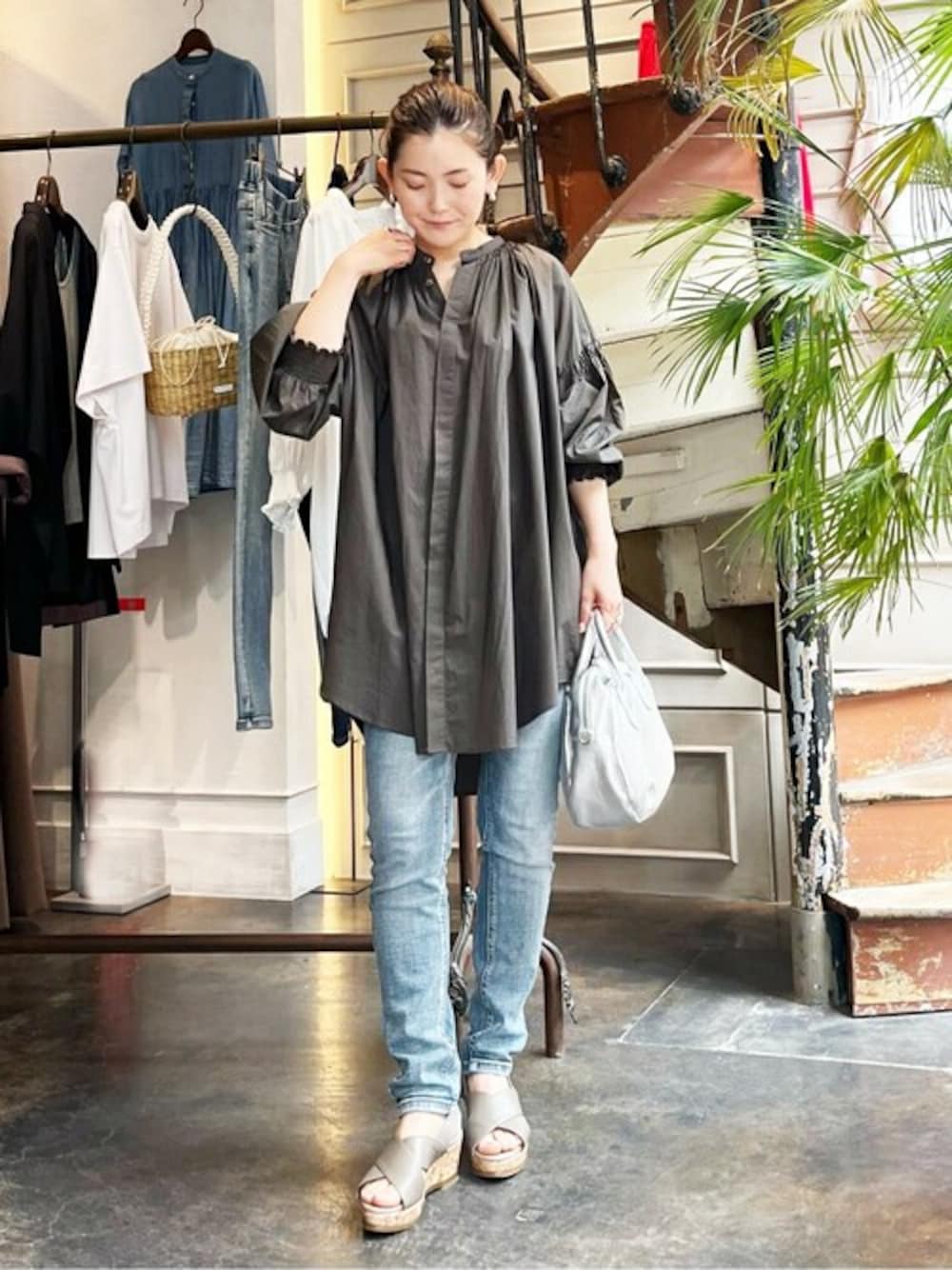 グレー系のシャツ/ブラウス、ブルー系のデニムパンツ、シルバー系のショルダーバッグを着用したレディースの夏コーディネートの1枚目の写真