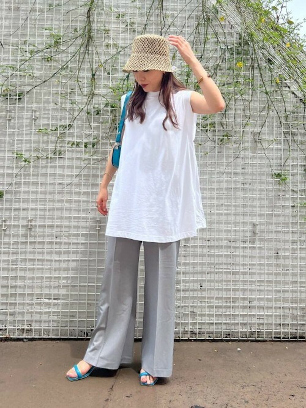 ブルー系のショルダーバッグ、ホワイト系のTシャツ/カットソー、グレー系のその他パンツを着用したレディースの春コーディネートの1枚目の写真