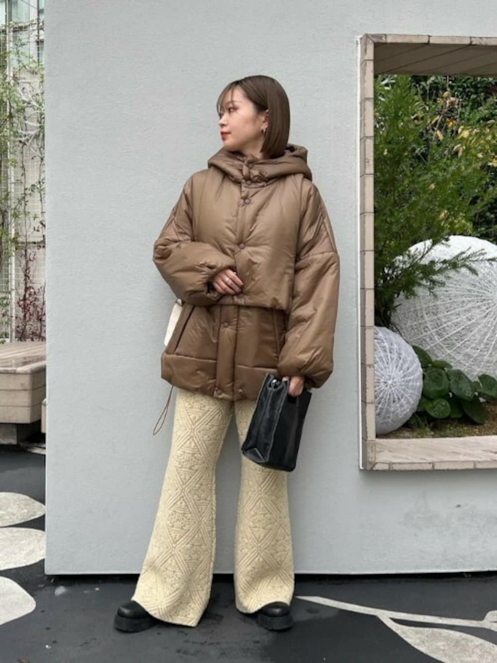 ブラウン系のブルゾン、イエロー系のその他パンツ、ブラック系のショルダーバッグを着用したレディースの冬コーディネートの1枚目の写真