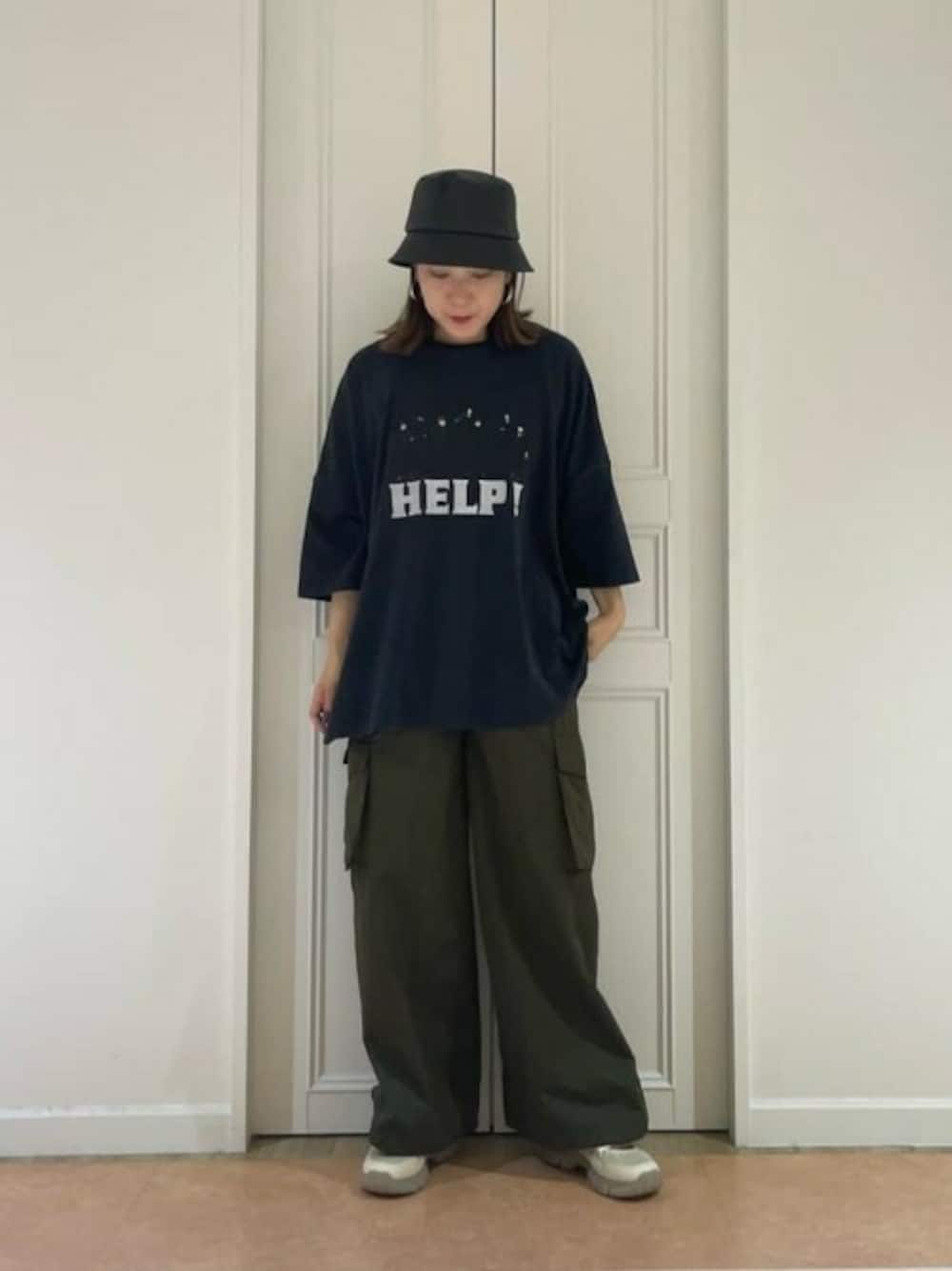 グリーン系のカーゴパンツ、ブラック系のTシャツ/カットソー、ベージュ系のスニーカーを着用したレディースの春コーディネートの1枚目の写真