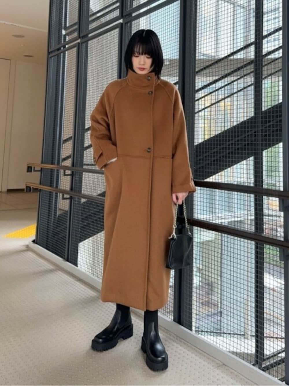 ブラウン系のその他アウター、ブラック系のショルダーバッグ、ブラック系のブーツを着用したレディースの冬コーディネートの1枚目の写真