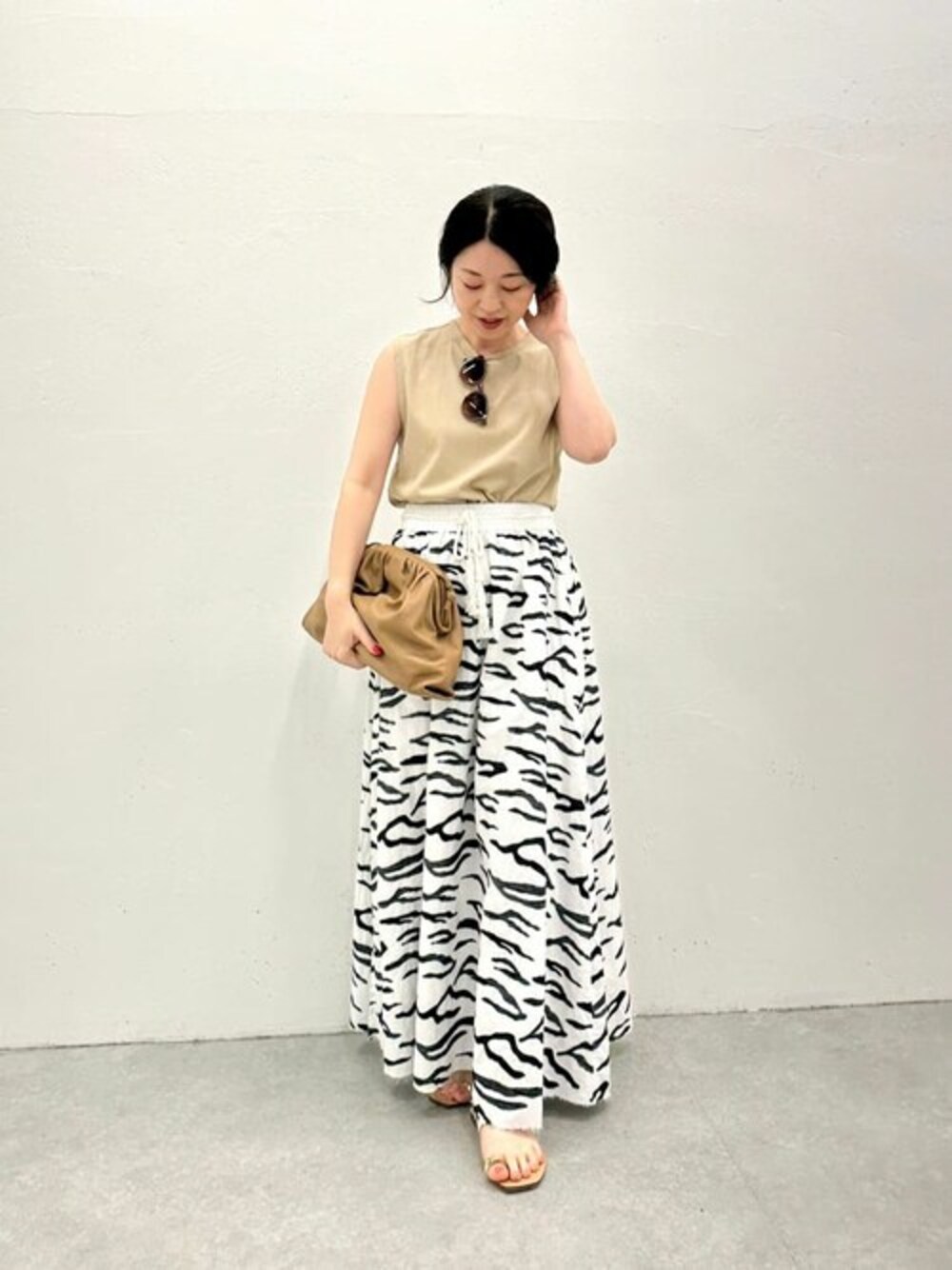 ベージュ系のTシャツ/カットソー、ホワイト系のスカート、イエロー系のハンドバッグを着用したレディースの春コーディネートの1枚目の写真