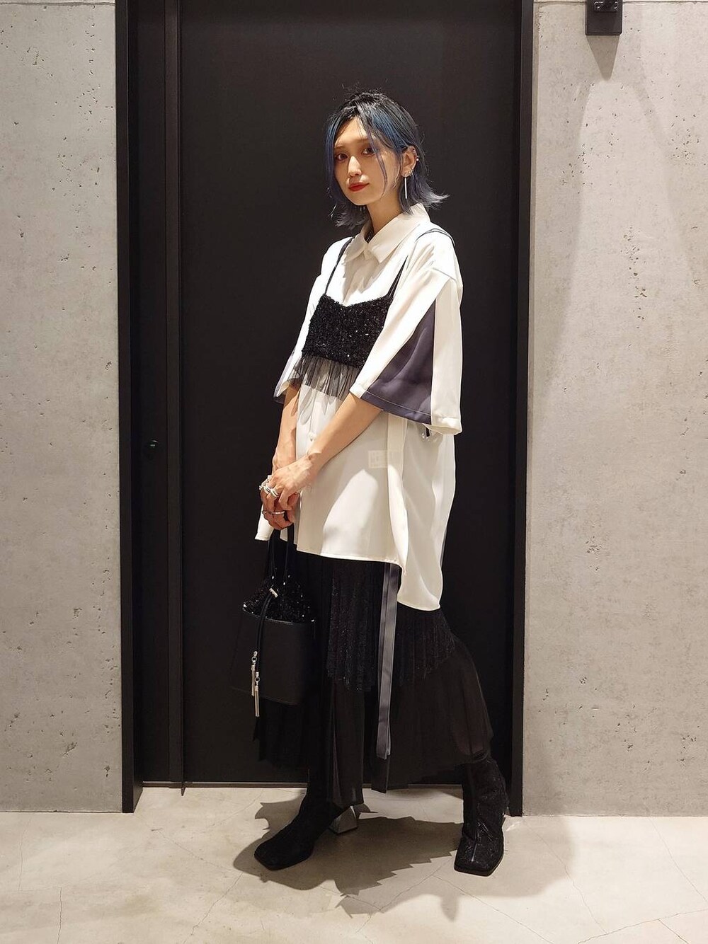 ブラック系のチューブトップ、ブラック系のスカート、ブラック系のショルダーバッグを着用したレディースの夏コーディネートの1枚目の写真