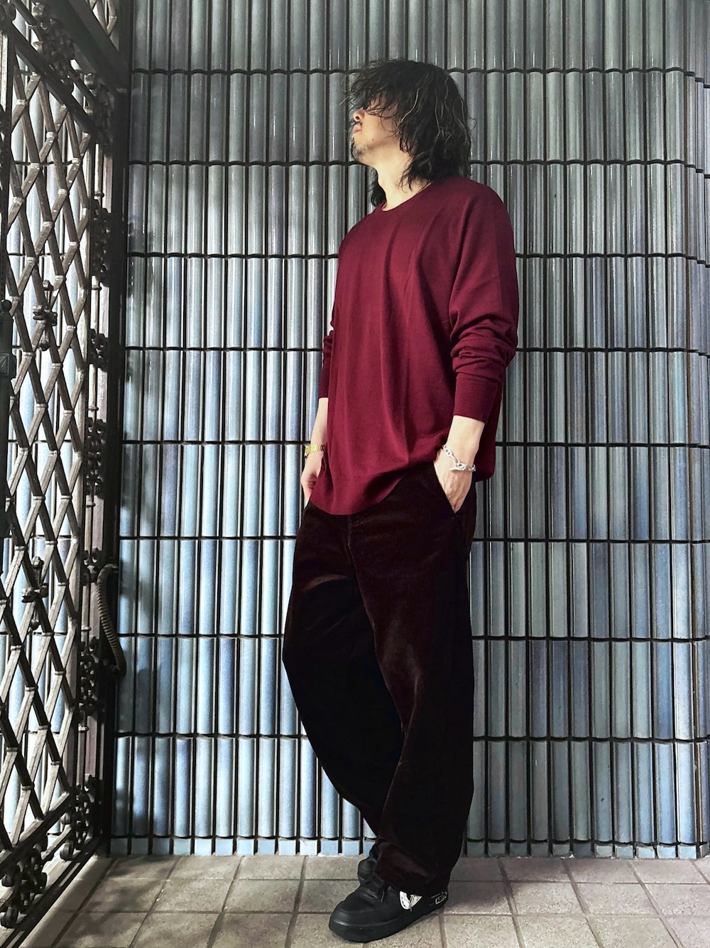 ブラック系のスニーカー、レッド系のニット/セーター、ブラウン系のその他パンツを着用したメンズの冬コーディネートの1枚目の写真