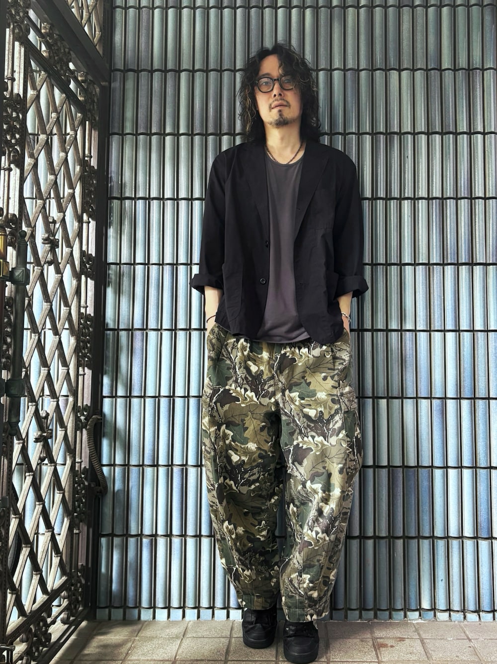 グリーン系のカーゴパンツ、ブラック系のスニーカー、グレー系のTシャツ/カットソーを着用したメンズの春コーディネートの1枚目の写真