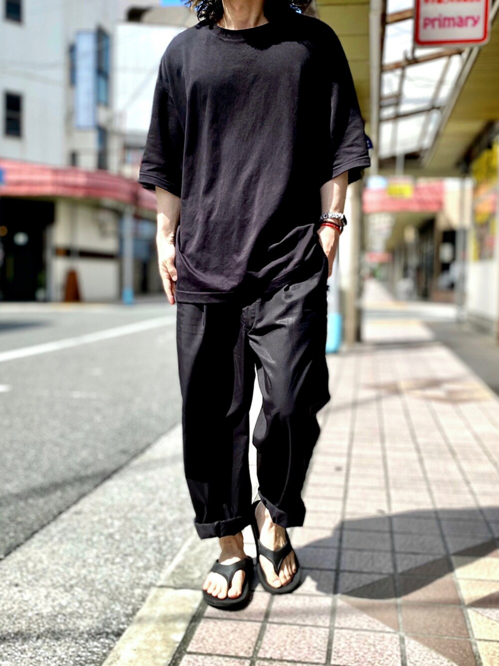 ブラック系のTシャツ/カットソー、ブラック系のその他パンツ、ブラック系のサンダルを着用したメンズの夏コーディネートの1枚目の写真