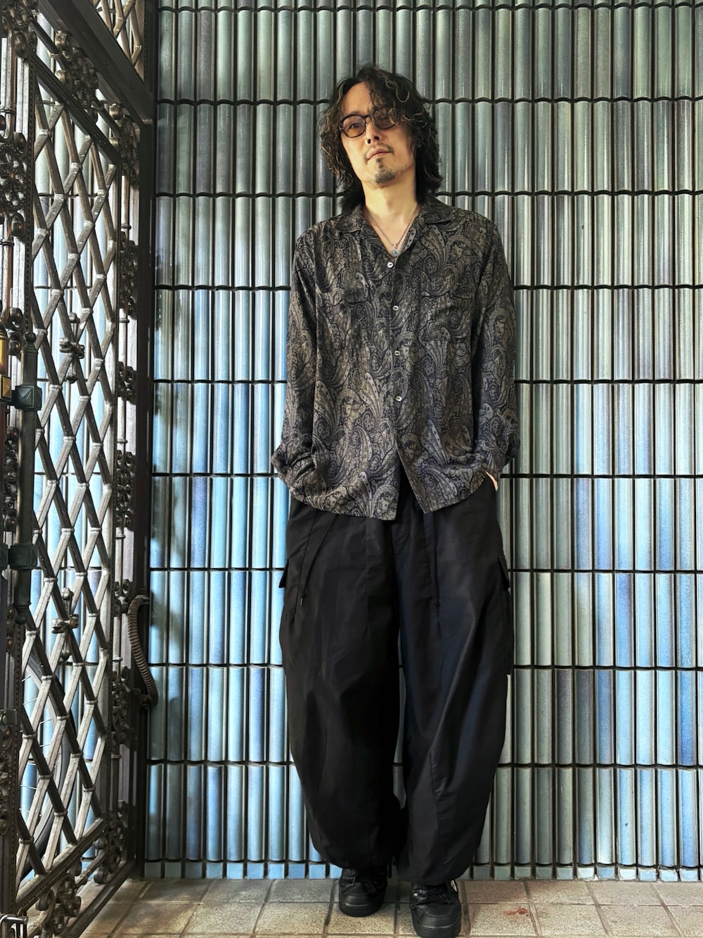 ブラック系のスニーカー、グレー系のシャツ/ブラウス、ブラック系のカーゴパンツを着用したメンズの秋コーディネートの1枚目の写真