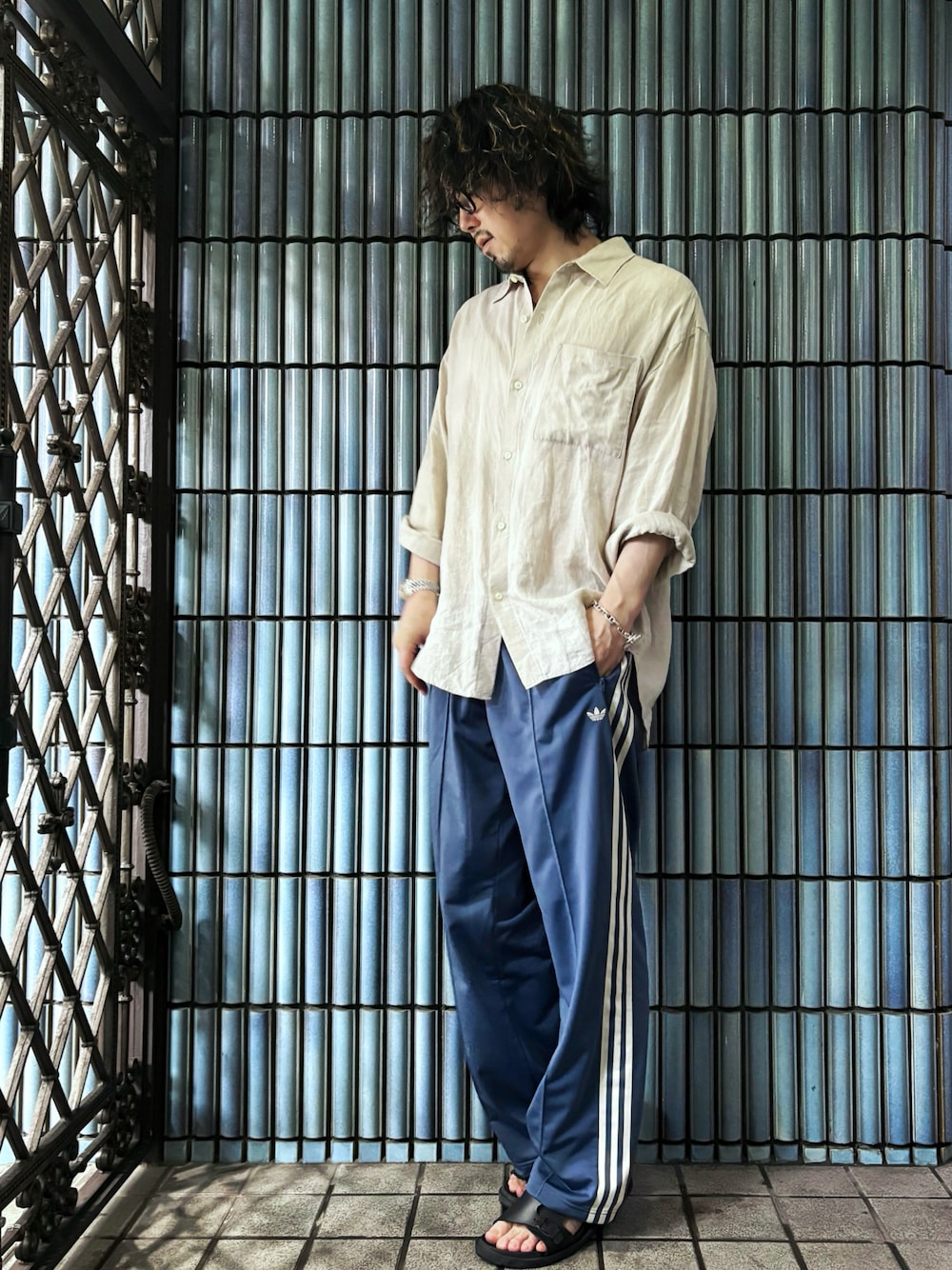 ベージュ系のシャツ/ブラウス、ブルー系のスウェットパンツ、ブラック系のサンダルを着用したメンズの夏コーディネートの1枚目の写真