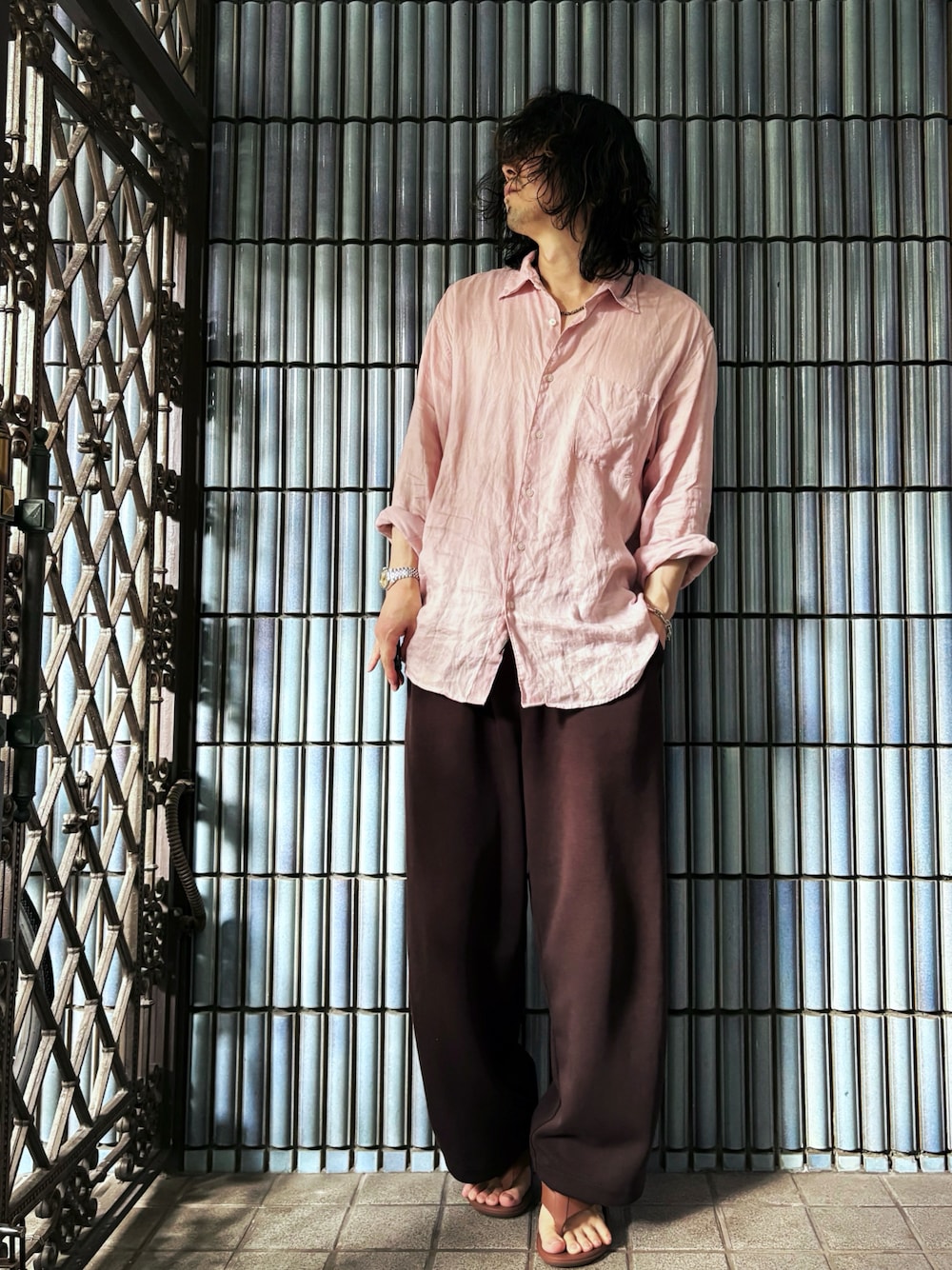 ブラウン系のサンダル、ピンク系のシャツ/ブラウス、ブラウン系のスウェットパンツを着用したメンズの秋コーディネートの1枚目の写真