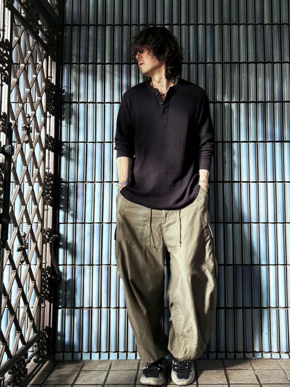 ブラック系のスニーカー、ブラック系のTシャツ/カットソー、グリーン系のカーゴパンツを着用したメンズの秋コーディネートの1枚目の写真