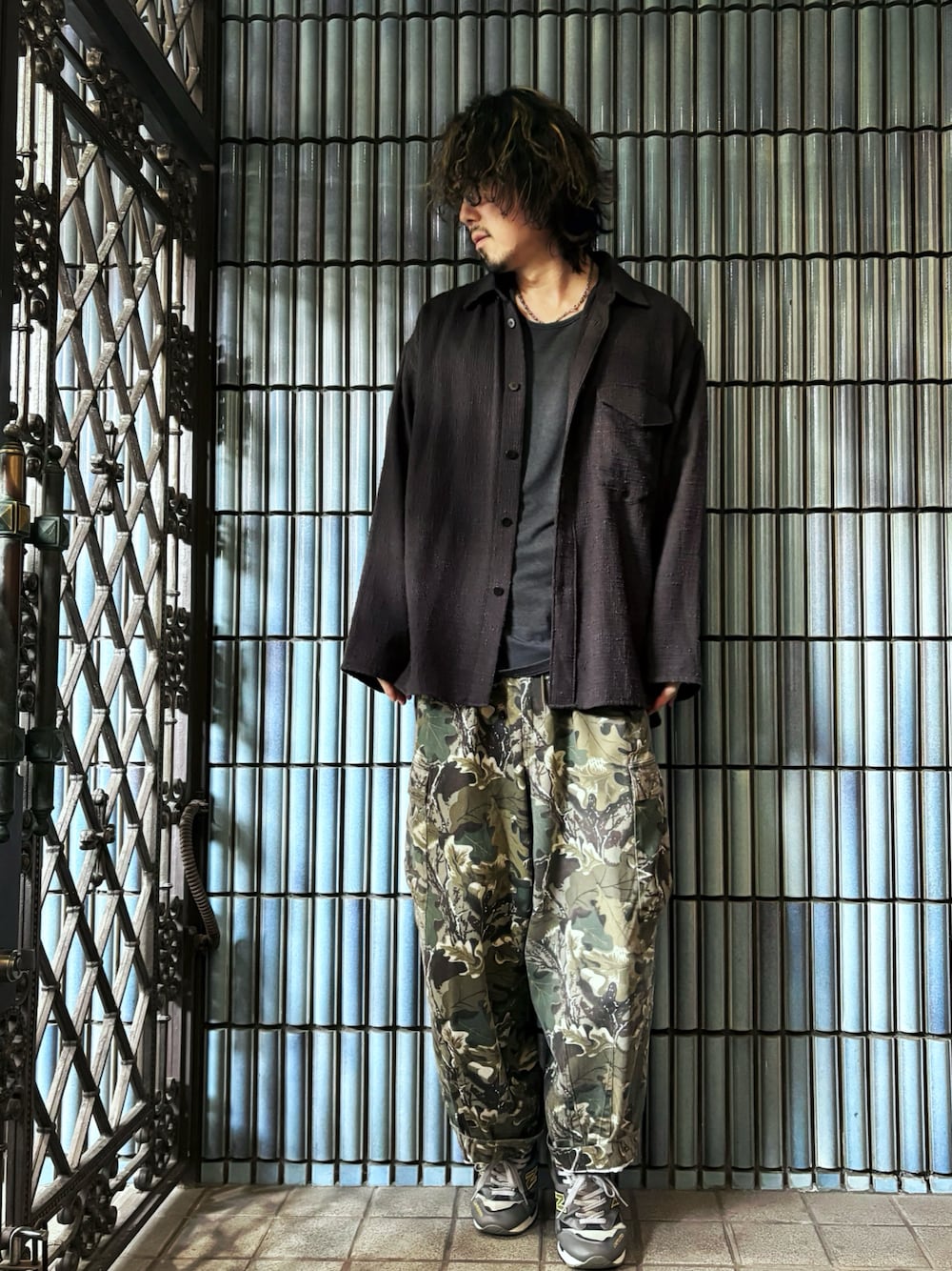 グリーン系のカーゴパンツ、グレー系のスニーカー、ブラック系のシャツ/ブラウスを着用したメンズの秋コーディネートの1枚目の写真