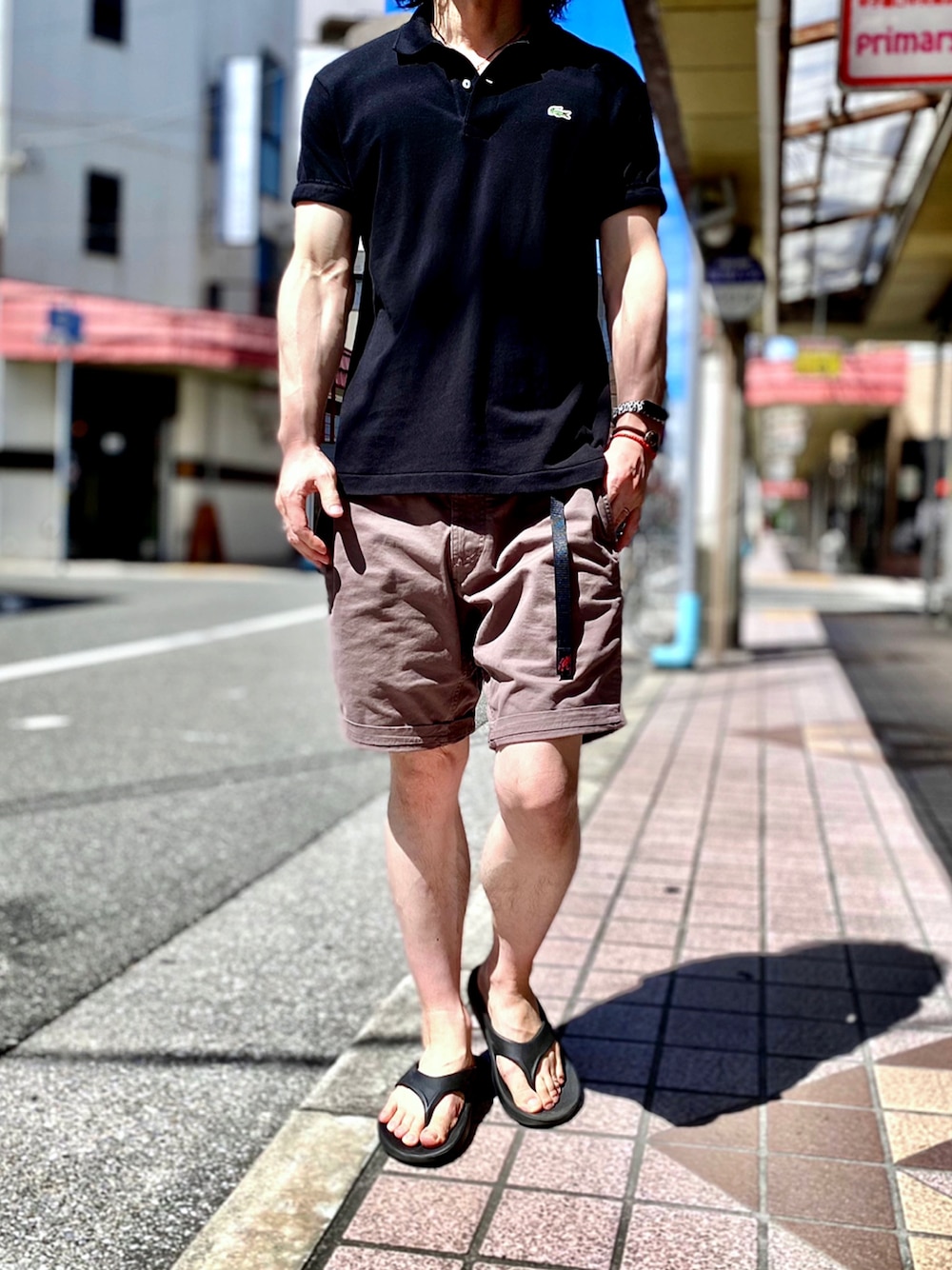 「GRAMICCI、グラミチ、ラコステ、ラコステ(LACOSTE)、LACOSTE、oofos、ウーフォス、ポロシャツ、ポロシャツコーデ、ショートパンツ、ハーフパンツ、ショーツ、ショーツスタイル、リカバリーサンダル、フレンチカジュアル」｜「LACOSTEの【LACOSTE / ラコステ】2 PLY REGULAR PIQUE（ポロシャツ、ブラック系）」を使った、KEITA(ΦωΦ)さん（メンズ・182cm）の夏コーディネートの1枚目の写真