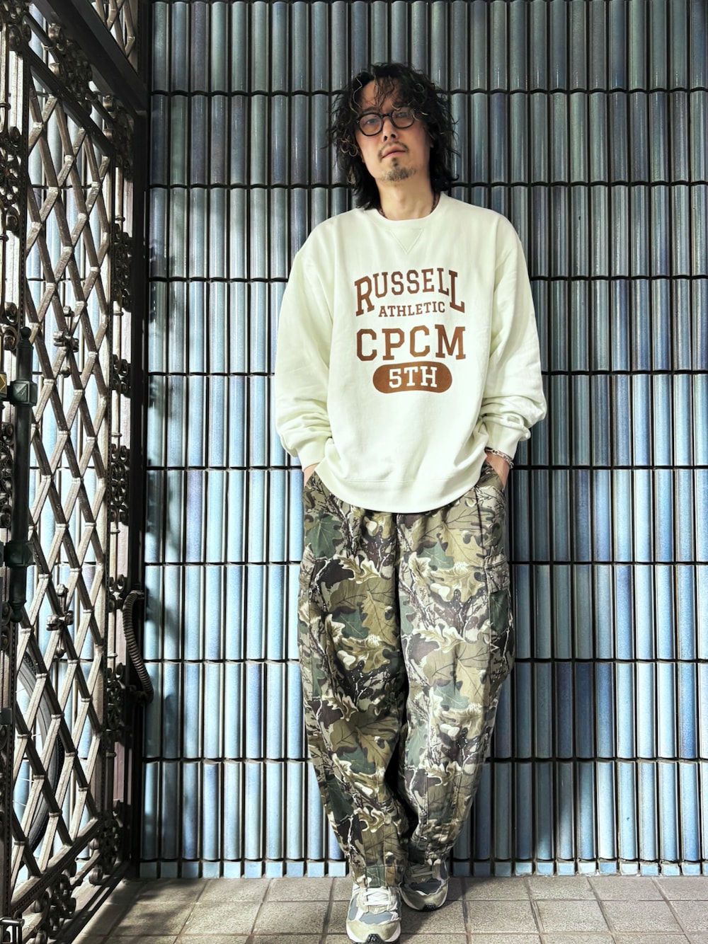 グリーン系のカーゴパンツ、ホワイト系のスウェット、グレー系のスニーカーを着用したメンズの春コーディネートの1枚目の写真