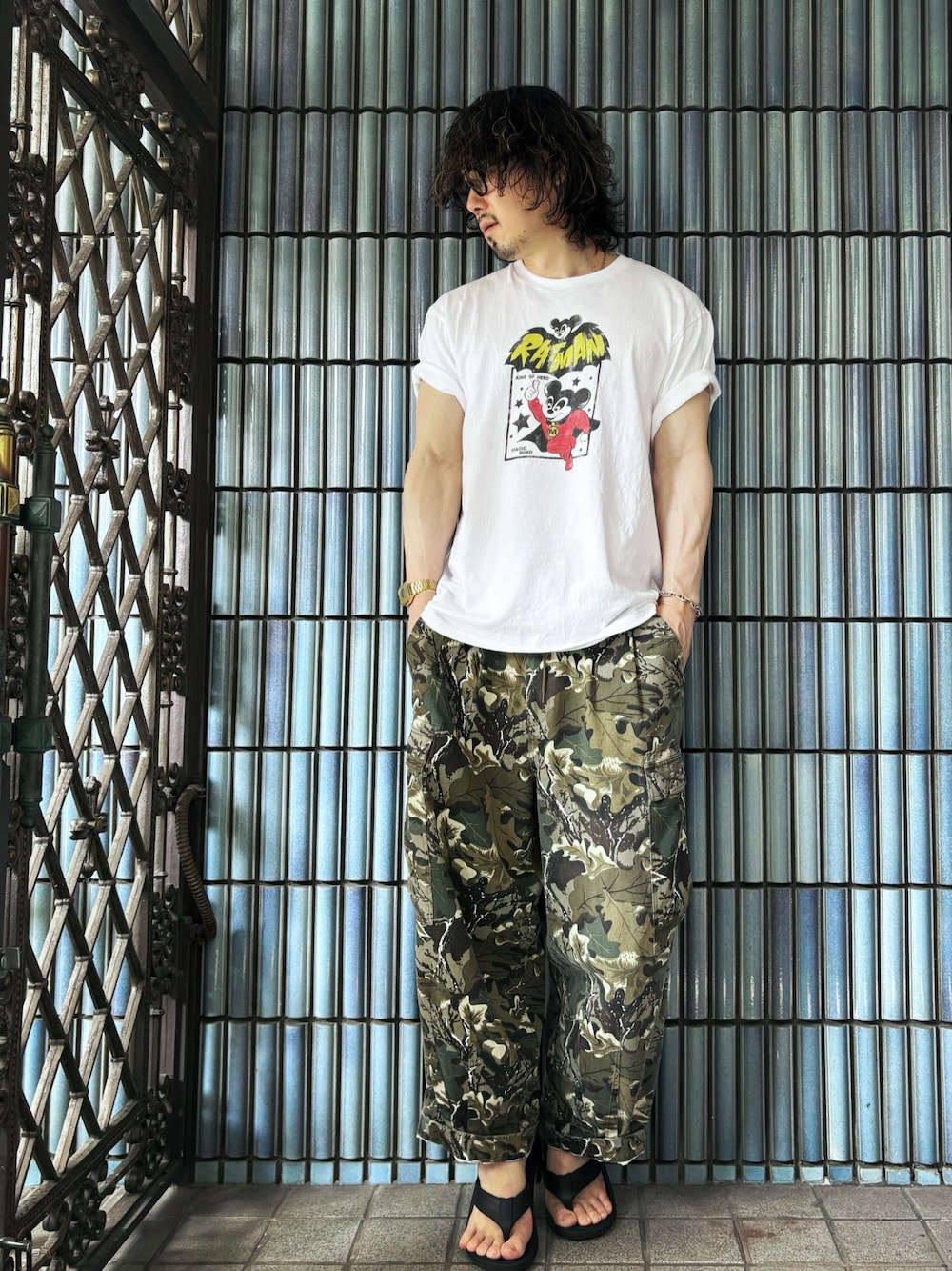 ブラック系のサンダル、グリーン系のカーゴパンツ、ホワイト系のTシャツ/カットソーを着用したメンズの夏コーディネートの1枚目の写真