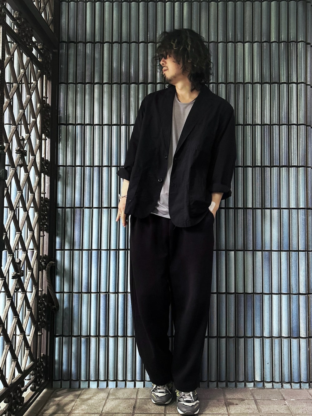 グレー系のスニーカー、グレー系のTシャツ/カットソー、ブラック系のテーラードジャケットを着用したメンズの春コーディネートの1枚目の写真