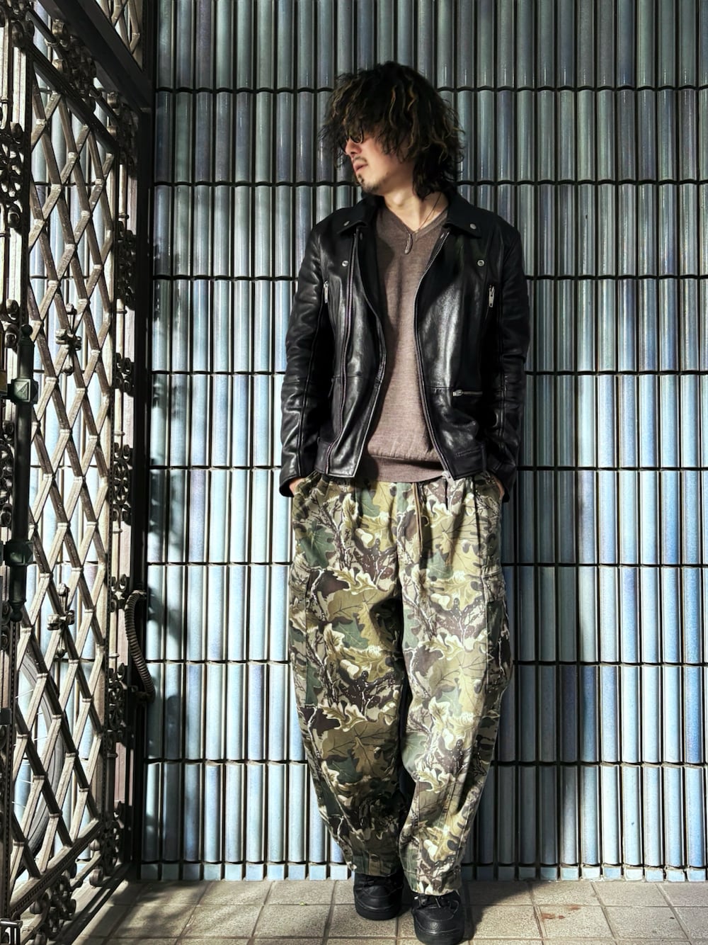 ブラウン系のニット/セーター、グリーン系のカーゴパンツ、ブラック系のスニーカーを着用したメンズの春コーディネートの1枚目の写真