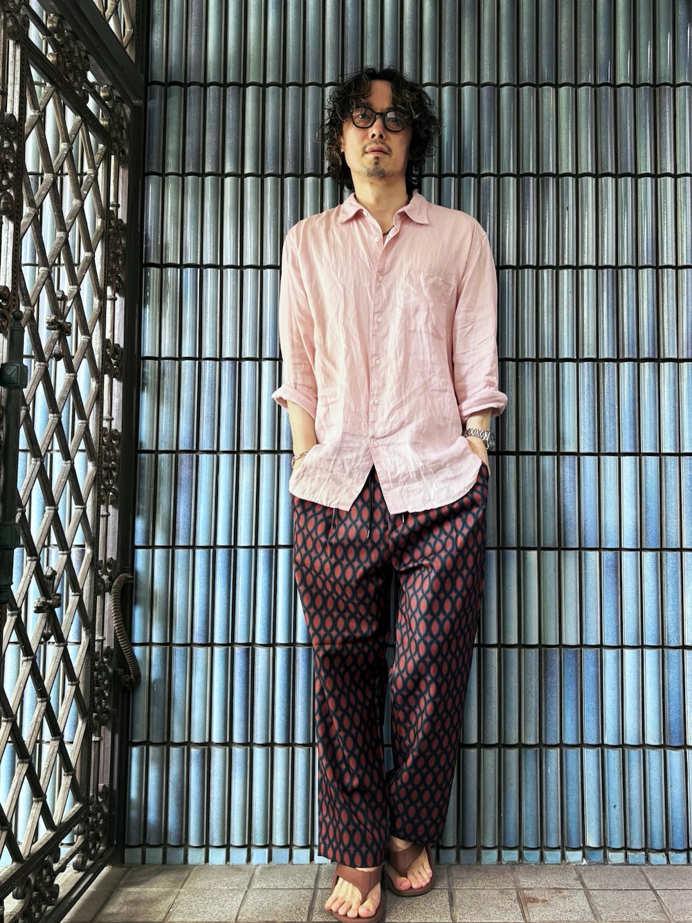 ブラウン系のサンダル、レッド系のその他パンツ、ピンク系のシャツ/ブラウスを着用したメンズの秋コーディネートの1枚目の写真