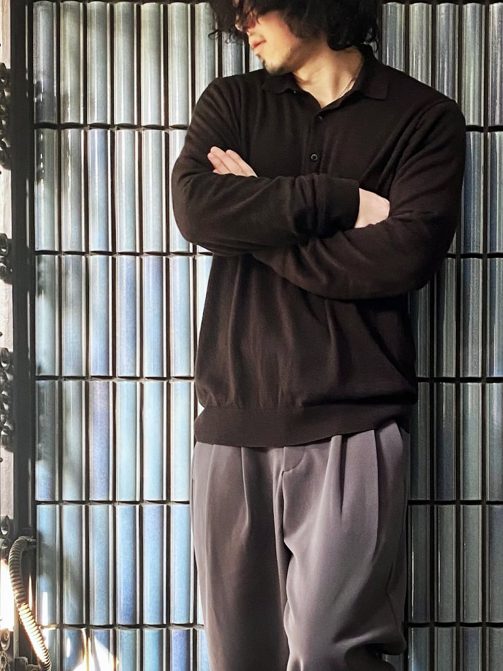 ブラウン系のポロシャツ、グレー系のその他パンツ、ブラック系のスニーカーを着用したメンズの春コーディネートの1枚目の写真