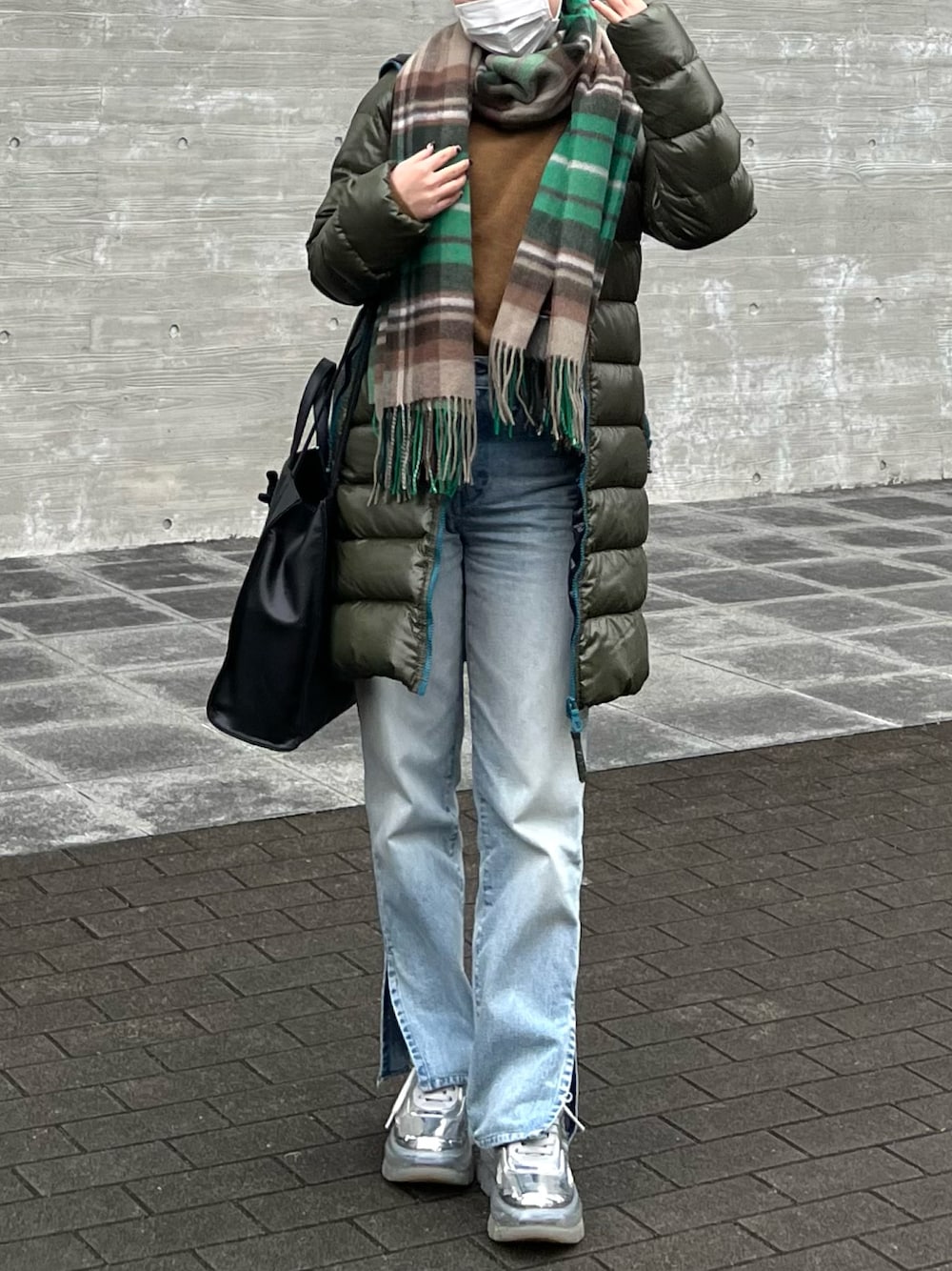 ブラウン系のニット/セーター、ブラック系のトートバッグ、ブルー系のデニムパンツを着用したレディースの冬コーディネートの1枚目の写真