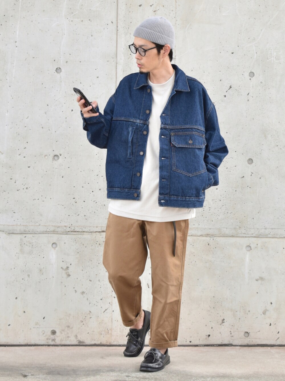 ブルー系のデニムジャケット、ブラウン系のチノパンツ、ブラック系のモカシン/デッキシューズを着用したメンズの夏コーディネートの1枚目の写真