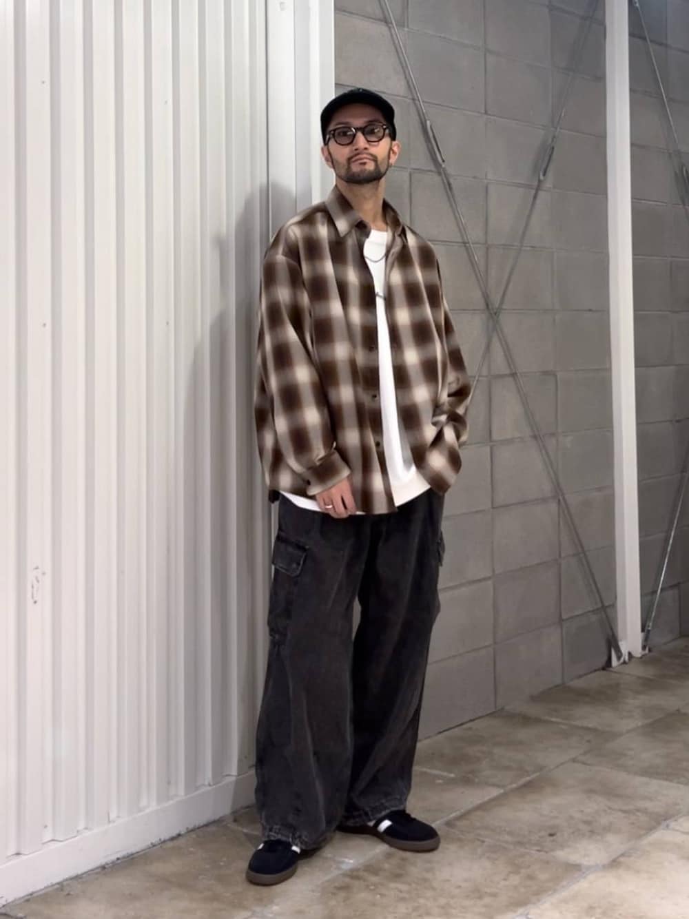 ブラック系のスニーカー、グレー系のデニムパンツ、ホワイト系のTシャツ/カットソーを着用したメンズの秋コーディネートの1枚目の写真