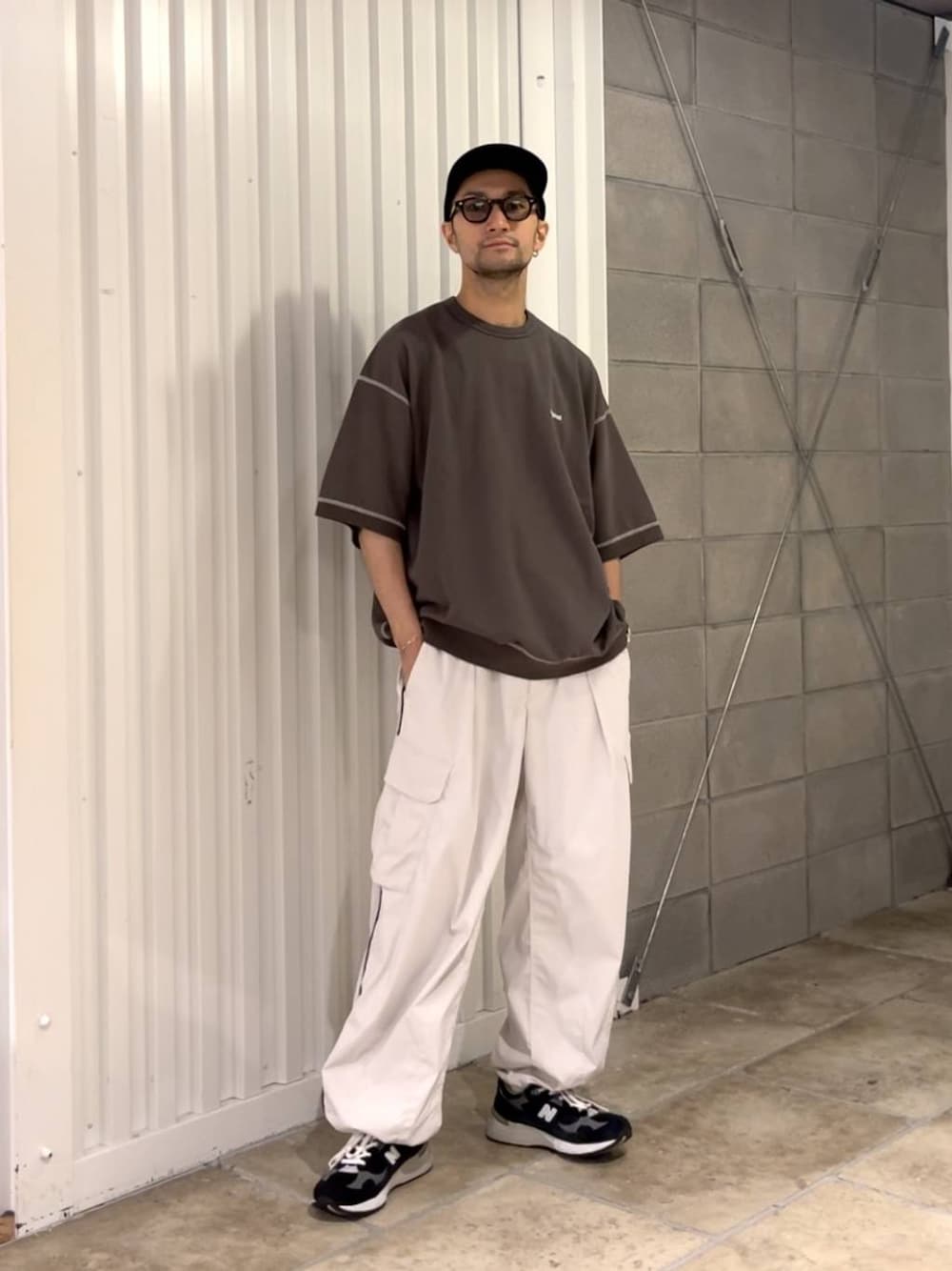 ブラック系のTシャツ/カットソー、ホワイト系のカーゴパンツを着用したメンズの夏コーディネートの1枚目の写真