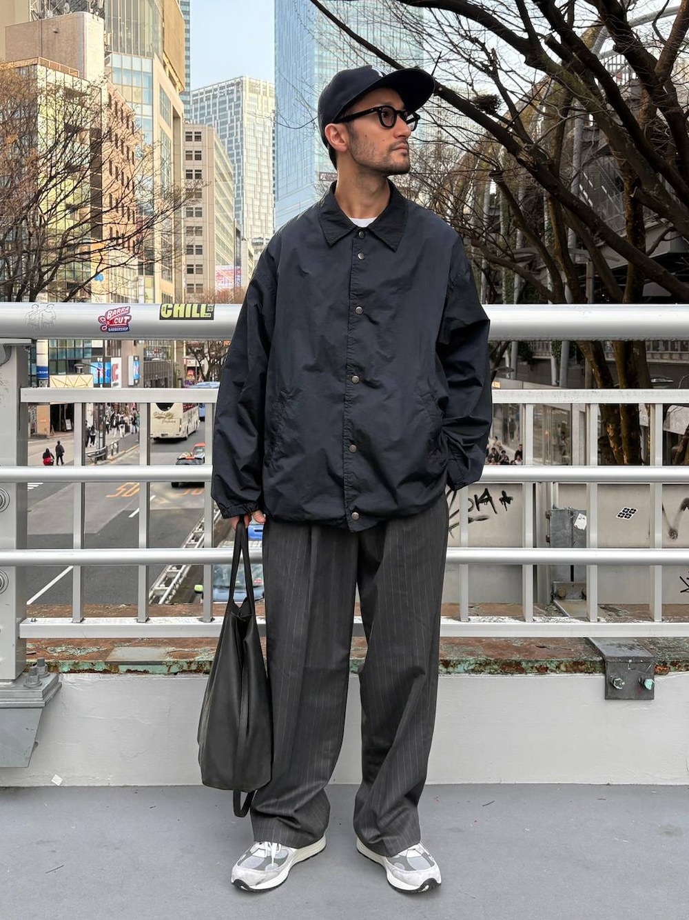 グレー系のスラックス、ホワイト系のTシャツ/カットソーを着用したメンズの春コーディネートの1枚目の写真