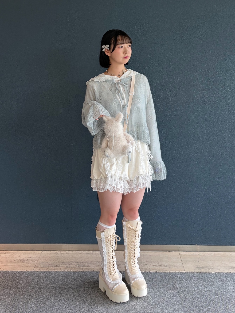 ホワイト系のTシャツ/カットソー、ブルー系のカーディガン/ボレロ、ホワイト系のショルダーバッグを着用したレディースの夏コーディネートの1枚目の写真