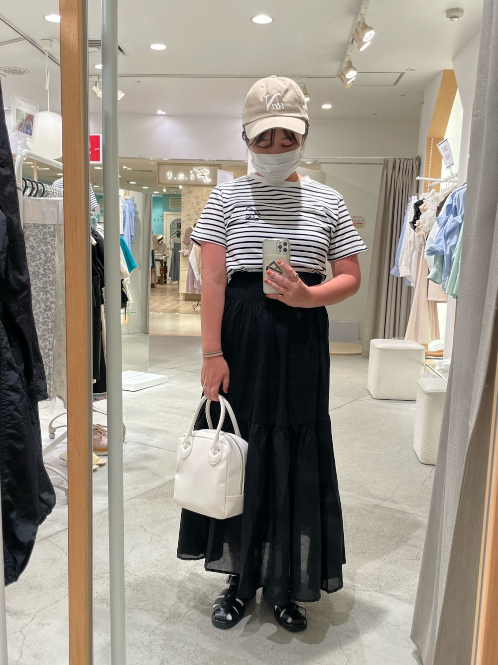 ブラック系のスカート、ホワイト系のショルダーバッグ、ホワイト系のTシャツ/カットソーを着用したレディースの夏コーディネートの1枚目の写真