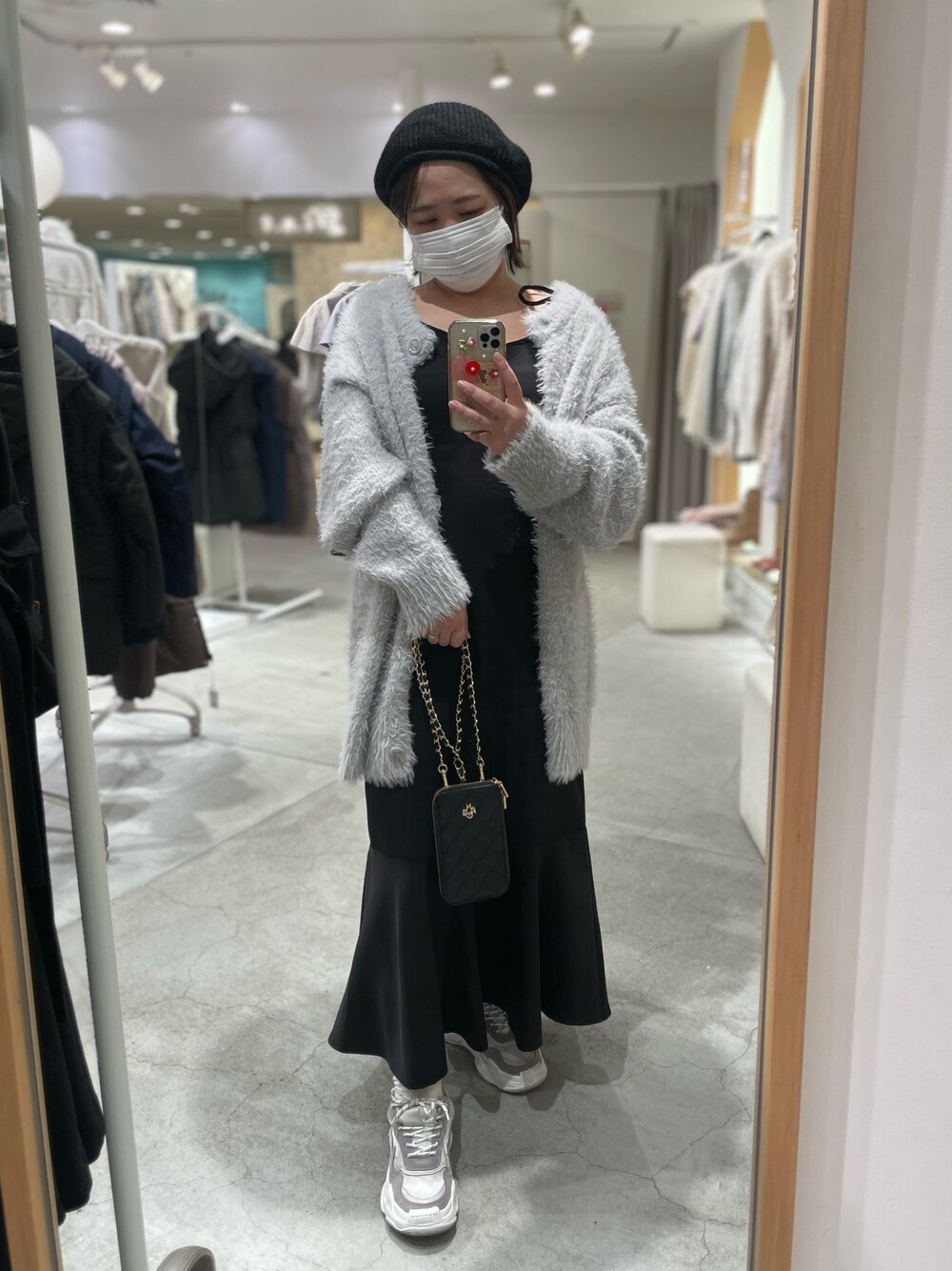 グレー系のカーディガン/ボレロ、ブラック系のワンピース、ブラック系のハンチング/ベレー帽を着用したレディースの秋コーディネートの1枚目の写真