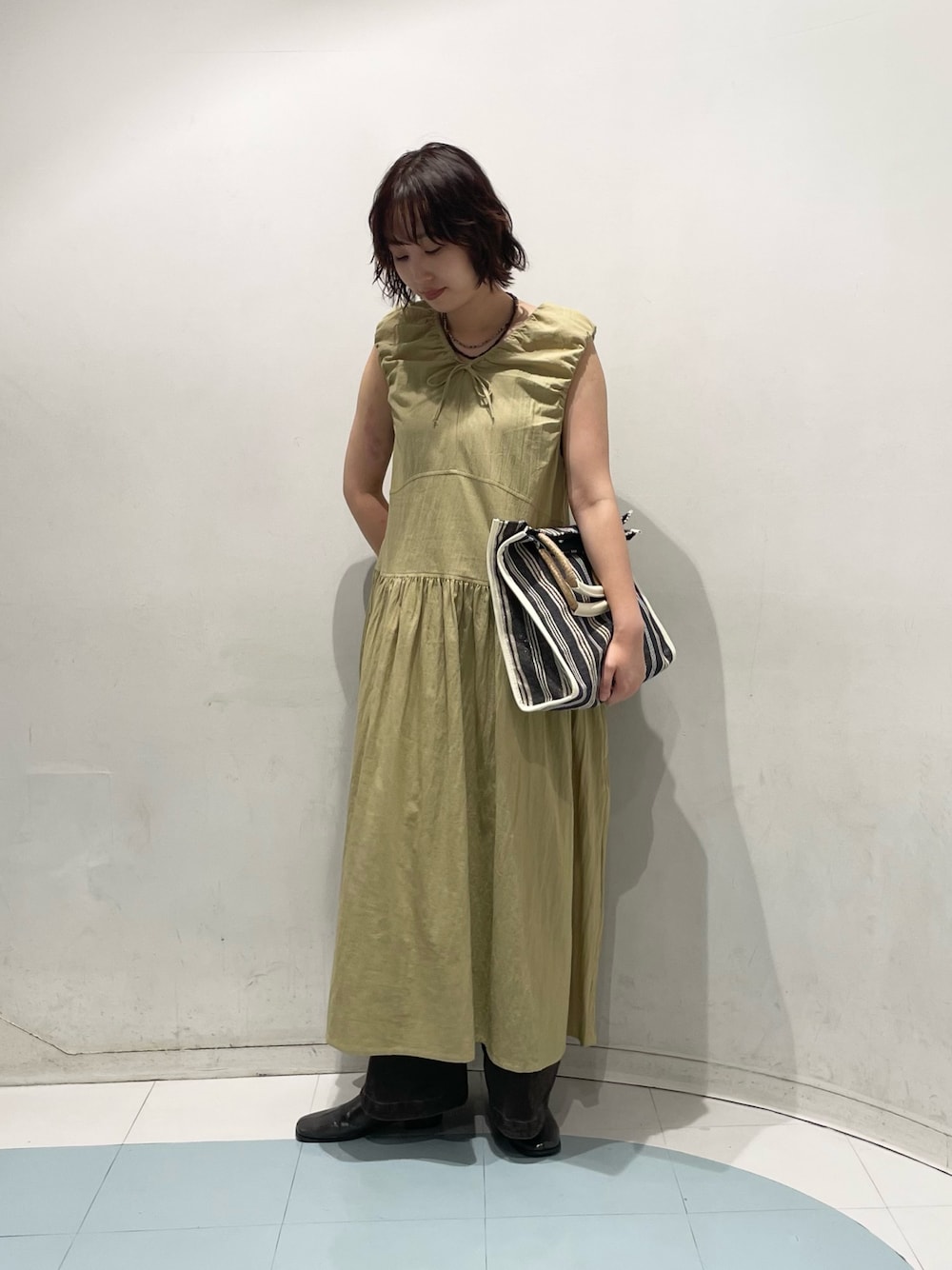 ベージュ系のワンピース、ブラウン系のその他パンツ、ホワイト系のトートバッグを着用したレディースの夏コーディネートの1枚目の写真
