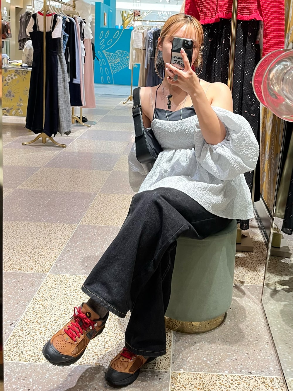 ブラック系のデニムパンツ、グレー系のシャツ/ブラウス、ブラック系のショルダーバッグを着用したレディースの秋コーディネートの1枚目の写真